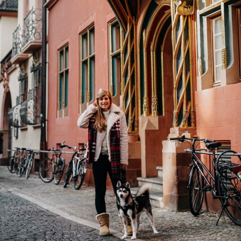 Frau mit Husky vor dem Eingang der Freiburger Meckelhalle in der Franziskanergasse