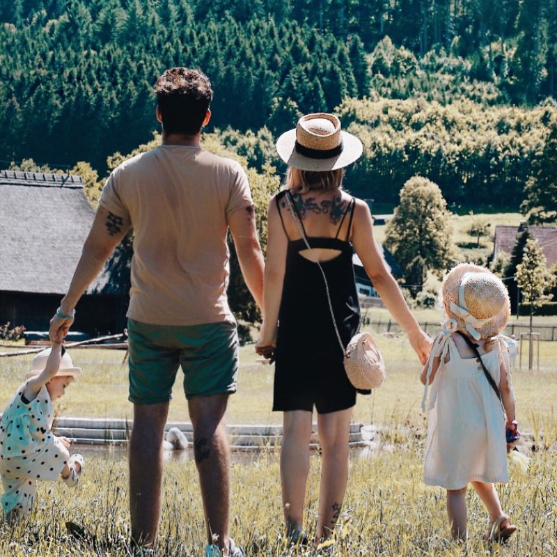 Familie mit zwei Kindern steht auf einer Wiese im Schwarzwald