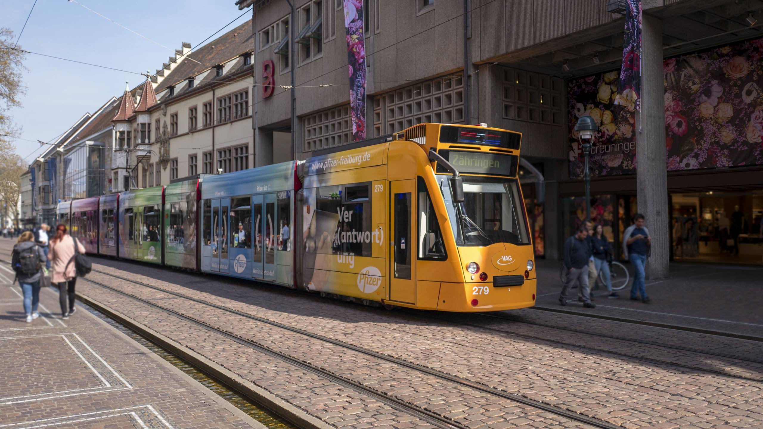 Die Straßenbahn mit dem Pfizer Design fährt in der Kaiser-Joseph-Straße in Freiburg 