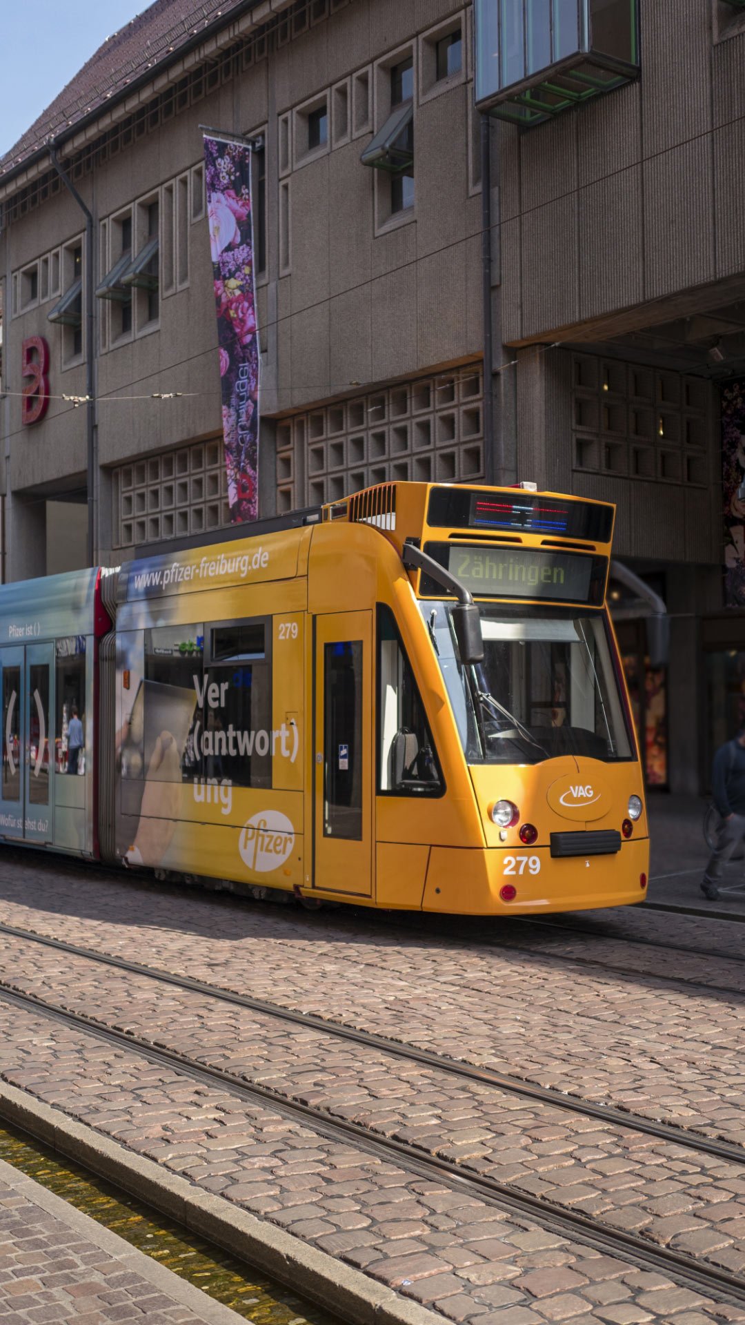 Die Straßenbahn mit dem Pfizer Design fährt in der Kaiser-Joseph-Straße in Freiburg 