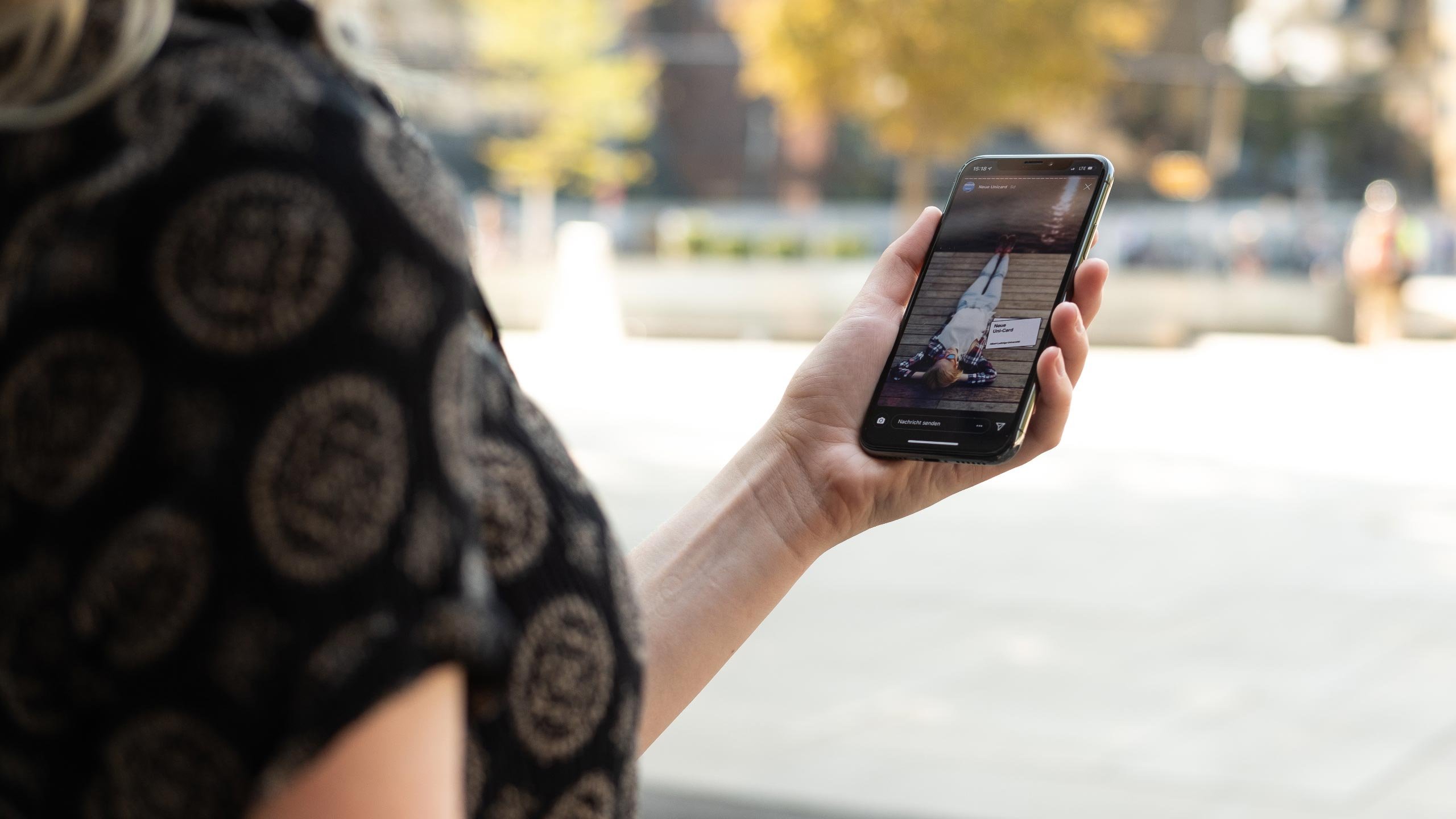 Das Keyvisual zum RVF SemesterTicket – eine entspannt auf einem Steg liegende Frau – ist auf einem Smartphone zu sehen